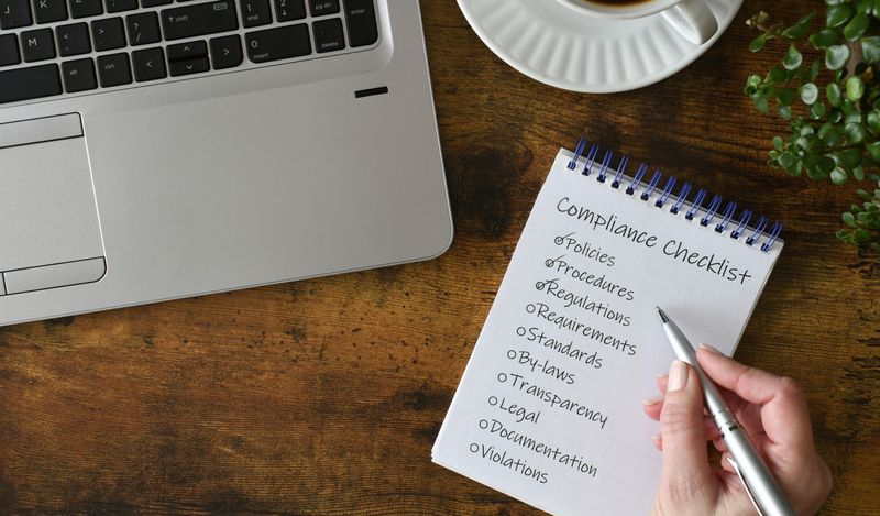 Image of a physical checklist next to the corner of a laptop.
