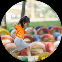 Small child walking across colourful tires