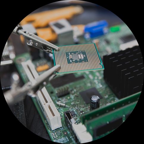 Benefits of Hardware Compatibility Testing image of a microchip being held by two crocodile clips above a motherboard.