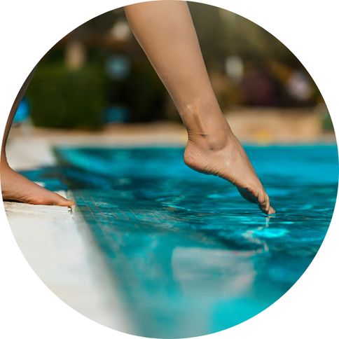 Image of a foot testing the temperature of pool water