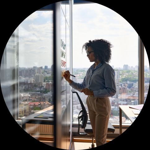 women at a glass screen using post it notes to create a test scenario