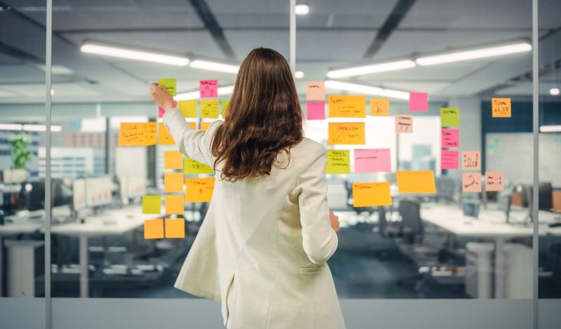 image of a women using post-it-notes on a window to create a plan